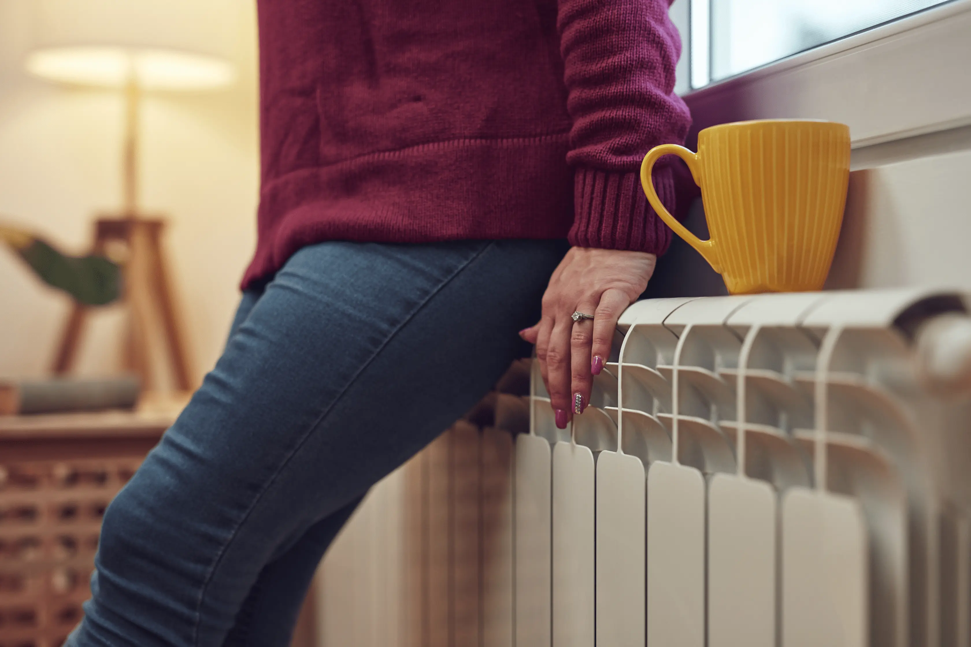Homeowner Resting On Radiator At Home